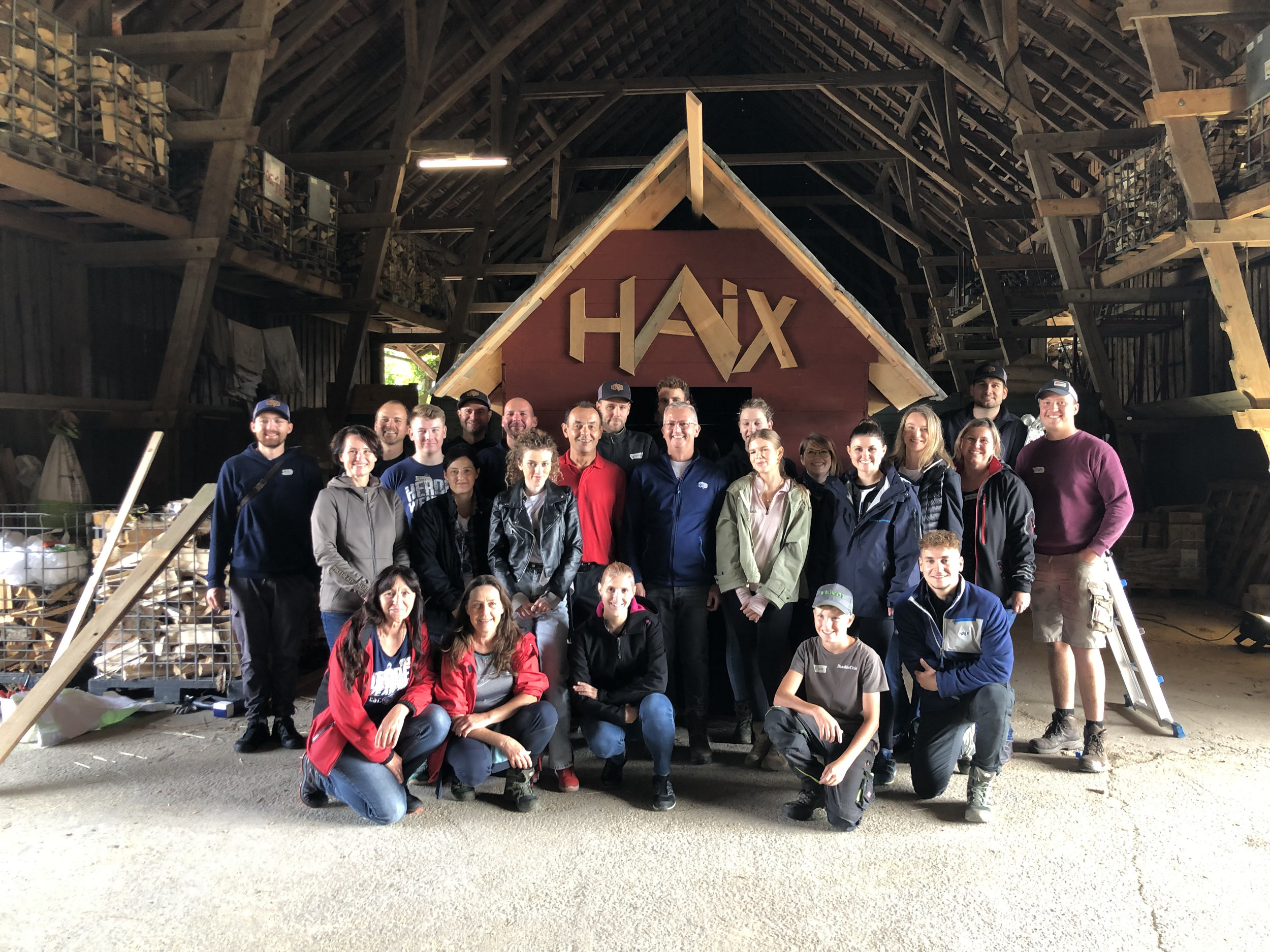 Gruppenfoto der Firma Haix vor einem Holz-Ziegenhaus