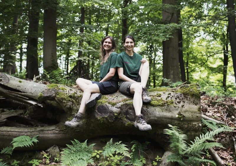 Lucia und Marlene Gruber auf einem Stamm im Wald